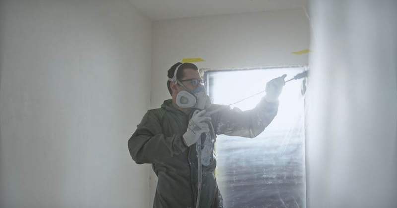 Painter spraying an interior wall